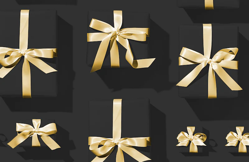 Gold gift bows on a dark surface